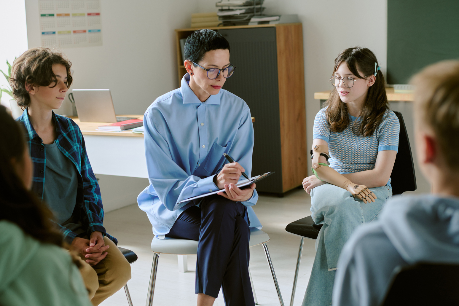 Coach e instructor de inteligencia emocional enseñando técnicas de gestión del estrés a grupo diverso en sala de formación.